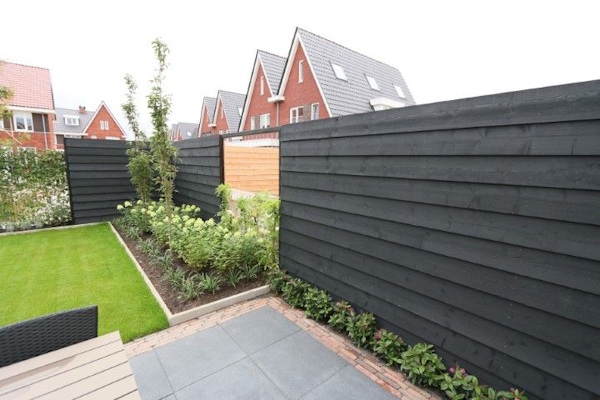 Moderne zwarte houten schutting behandeld met Induline GW-310 beits, voor duurzame bescherming tegen schimmels en weersinvloeden